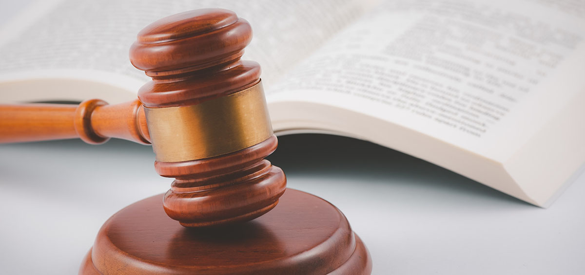 Old wood Judge hammer with law book on the table wood background