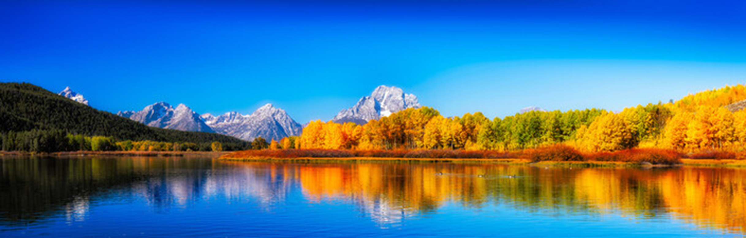 Figure&nbsp;2 &ndash; View of a watercourse surrounded by forest and mountains in the distance.