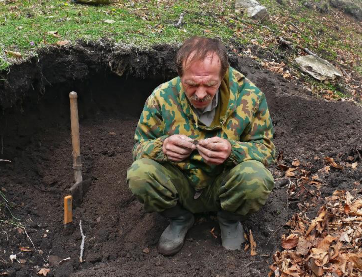 Figure&nbsp;6 &ndash; Man examining a discovered object inside an excavation
