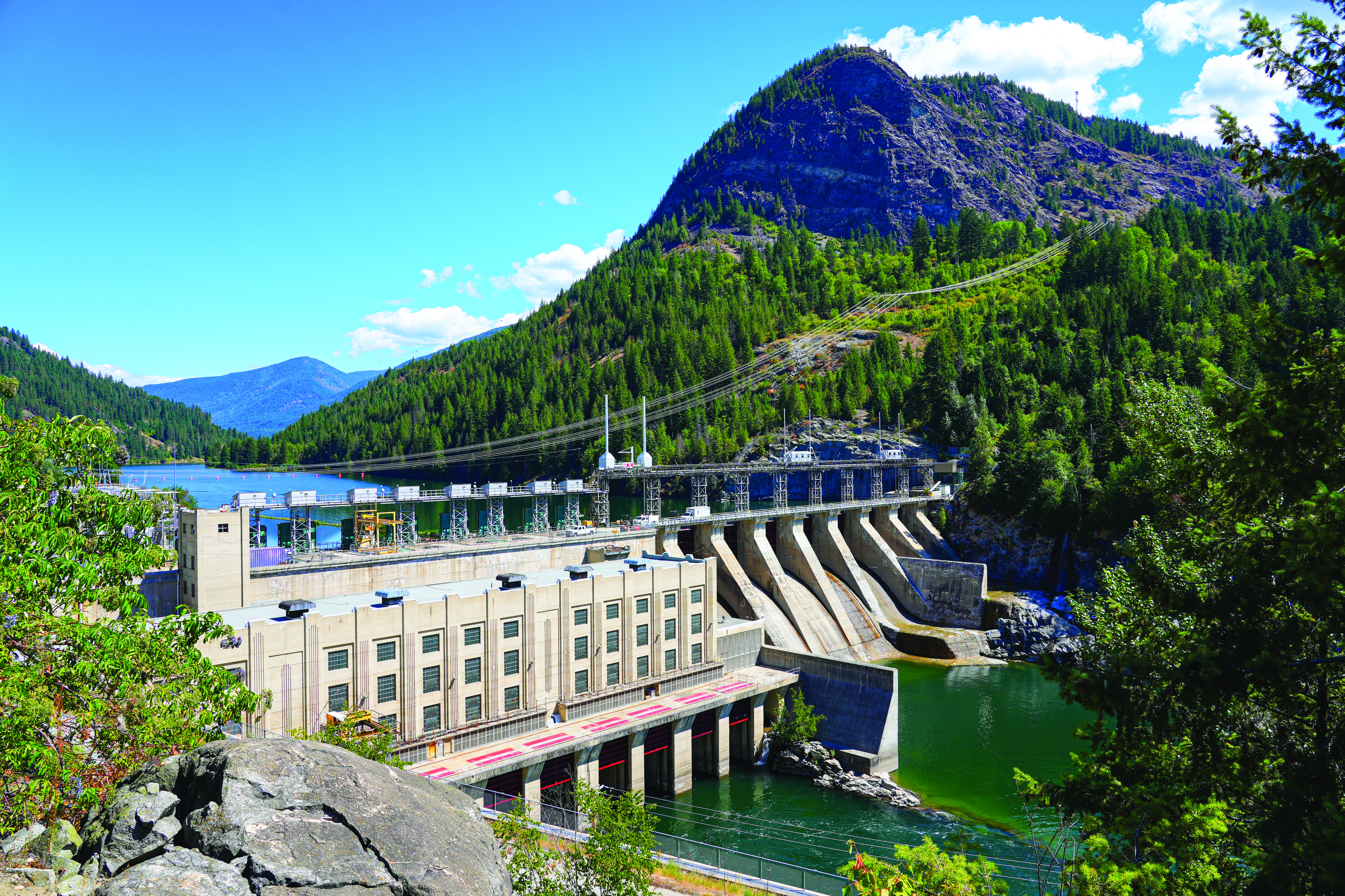 Barrage hydroélectrique sur la rivière Kootenay, en amont de Castlegar, dans la région de West Kootenay, en Colombie-Britannique, sous un ciel ensoleillé.